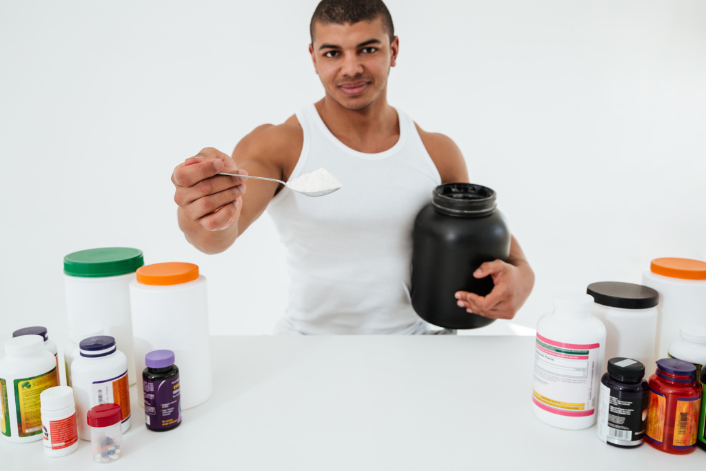 sportsman-standing-white-wall-holding-vitamins.jpg
